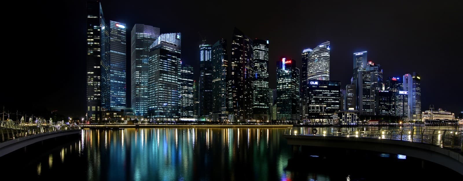 Singapore's Central Business District skyline lit up at night, seen across Marina Bay
