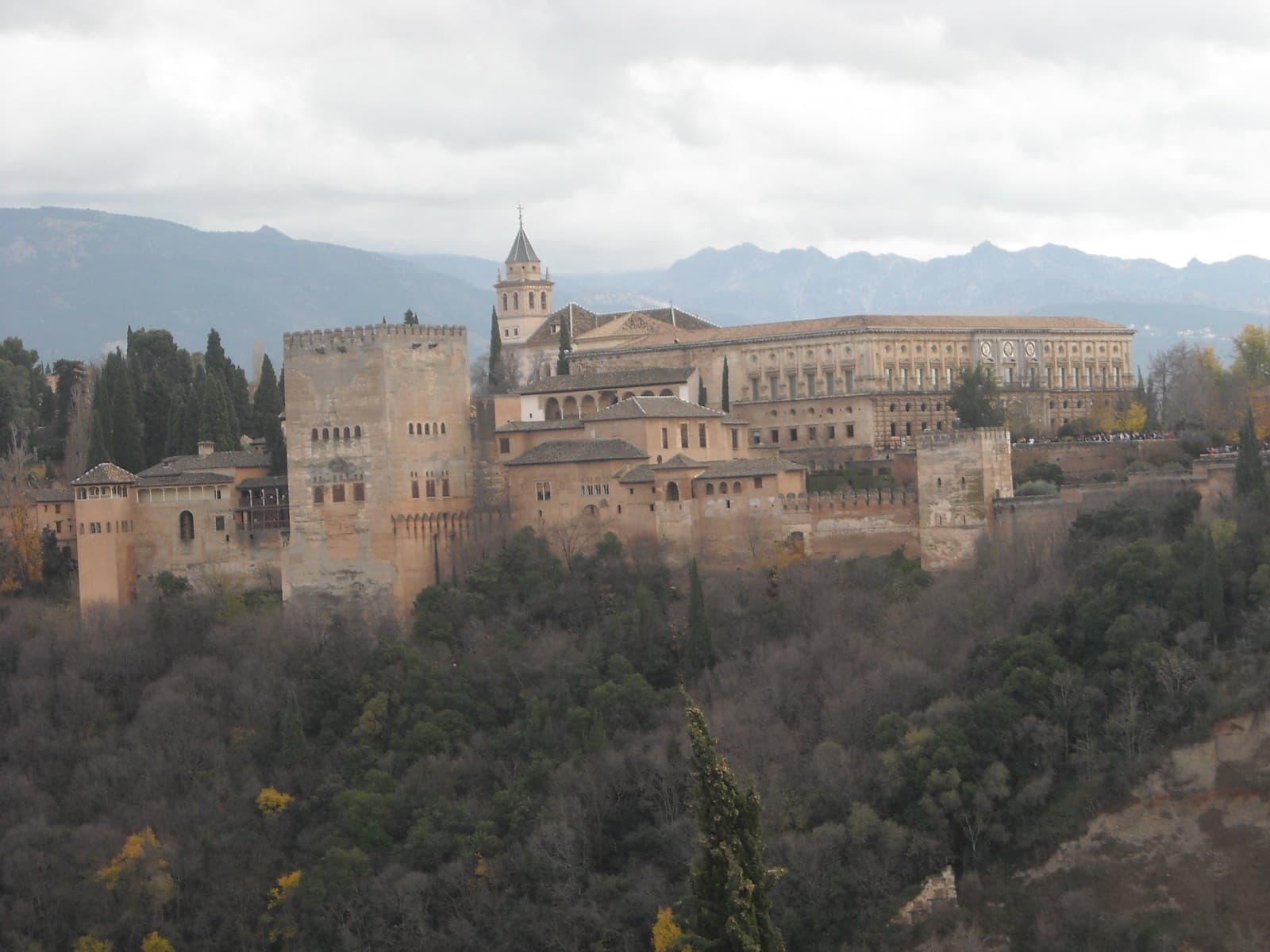 The Alhambra palace and fortress complex on its hilltop above Granada, with the Sierra Nevada mountains behind it